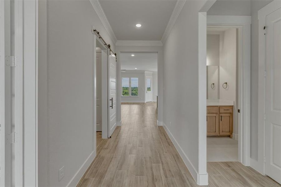 Hallway with wood-finish tile flooring, recessed lighting, and crown molding Hallway with wood-finish tile flooring, recessed lighting, and crown molding