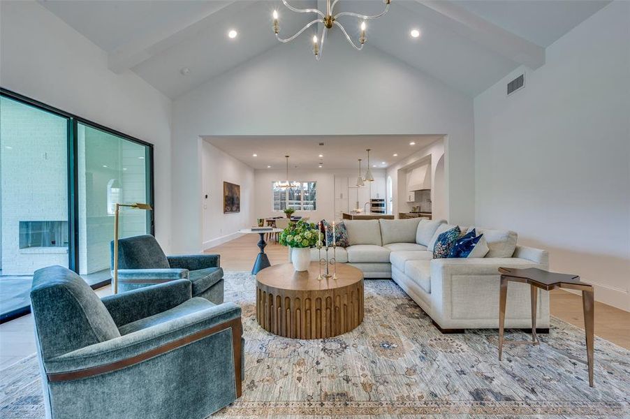 Living area featuring a chandelier, wood finished floors, high vaulted ceiling, recessed lighting, and beamed ceiling