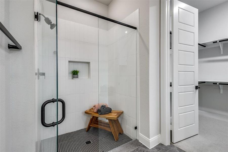 Full bath with a stall shower and a walk in closet