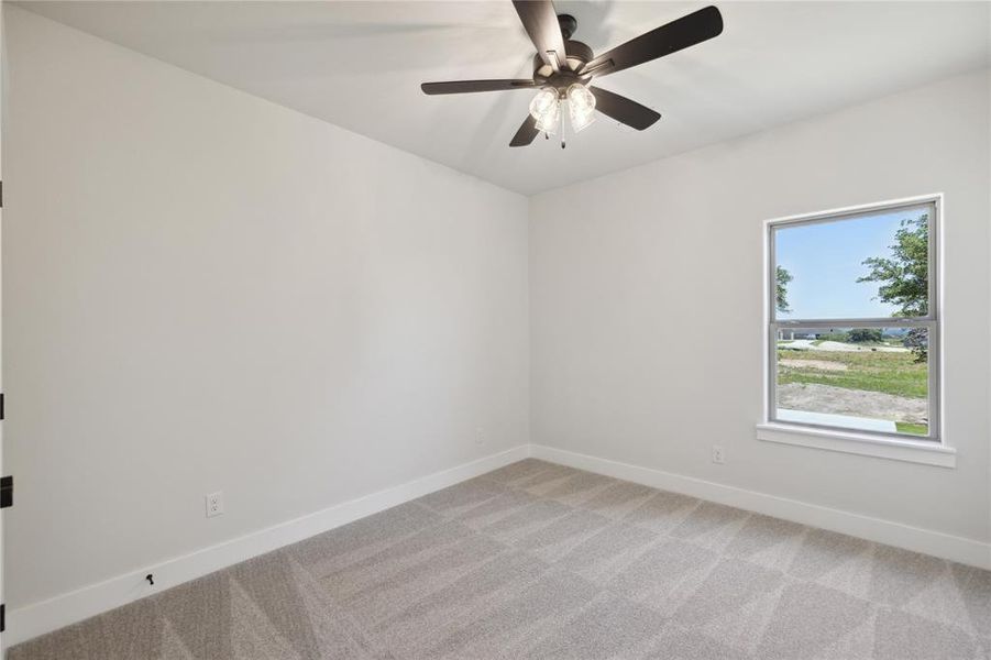 Carpeted empty room with ceiling fan