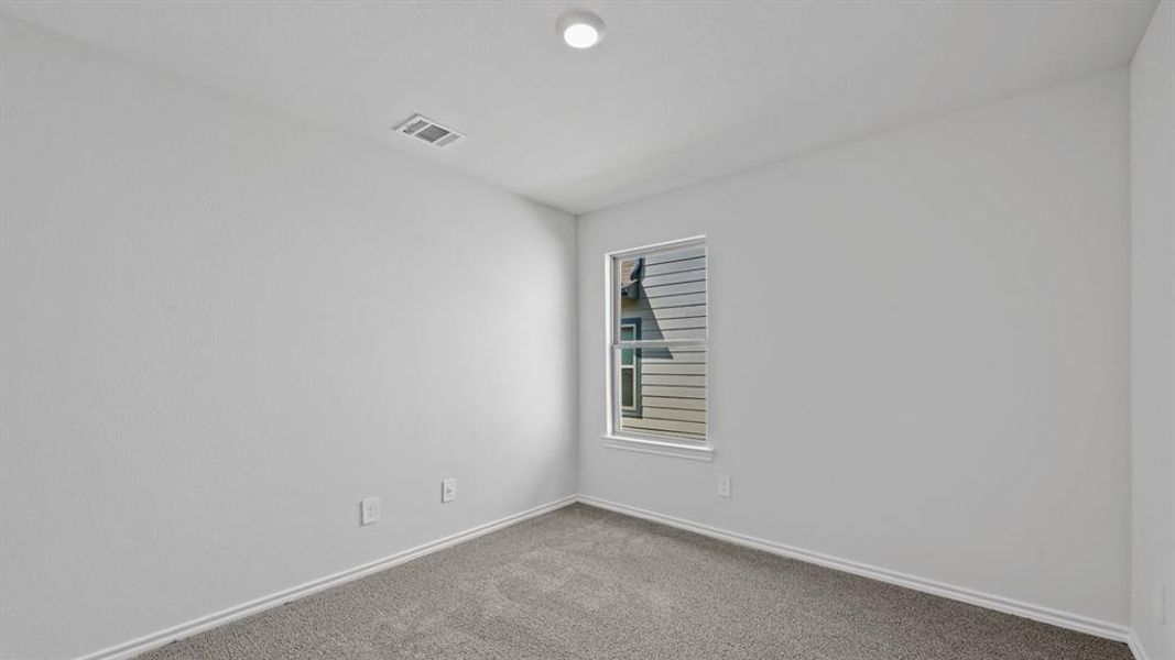 Neutral white walls with a single window and recessed ceiling lighting
