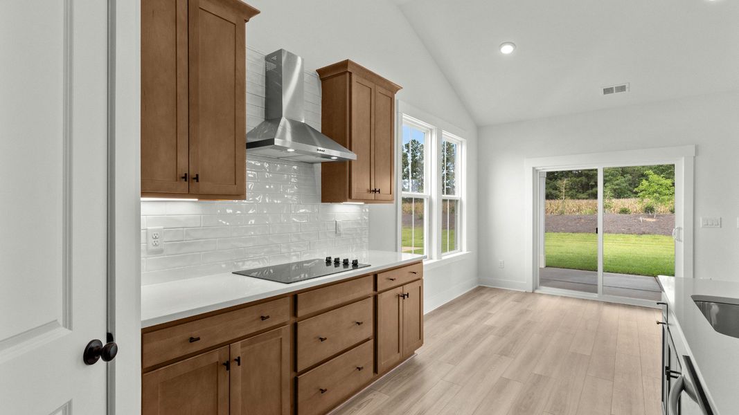 Gourmet kitchen featuring stove and tile backsplash at Chestnut Farms by DRB Homes