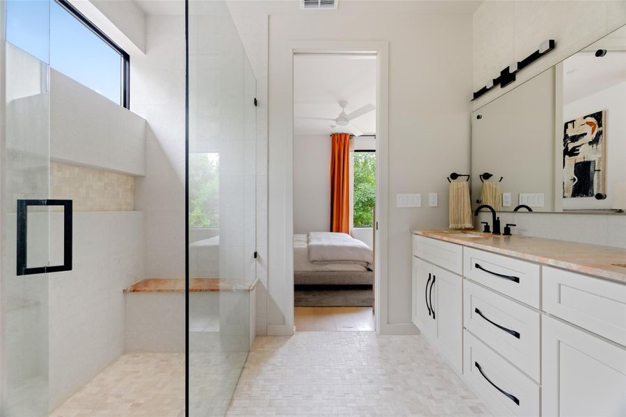 Full bath with visible vents, connected bathroom, vanity, and tiled shower