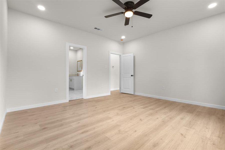 Spacious room featuring wood-finish flooring, recessed lighting, and a ceiling fan