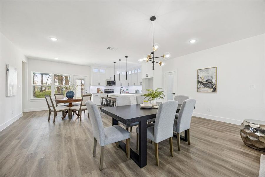 Dining room with a chandelier looking towards the kitchen.