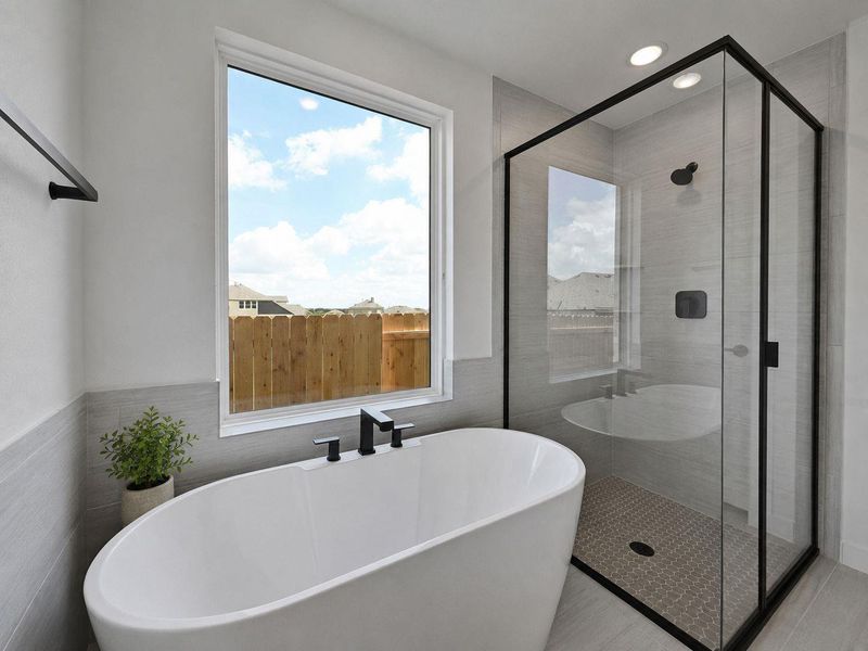 Indulge in a tranquil retreat featuring a deep soaking tub and a spacious, contemporary walk-in shower.