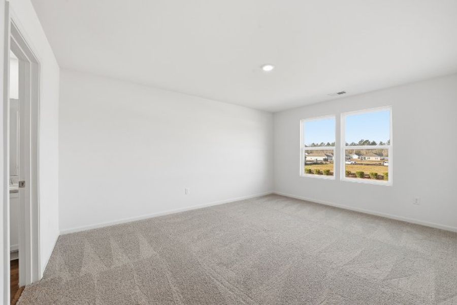 A room with a carpet and a window.