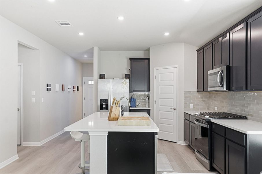 Rich espresso cabinetry adds a touch of elegance that anchors the homes bright design.