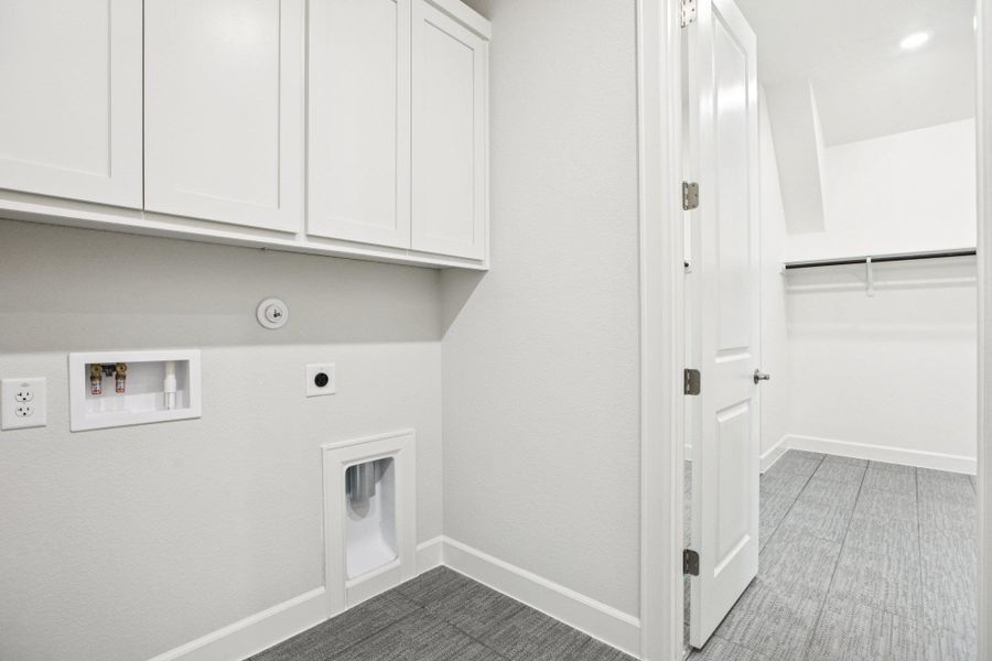 Washroom with cabinet space, washer hookup, electric dryer hookup, and light carpet