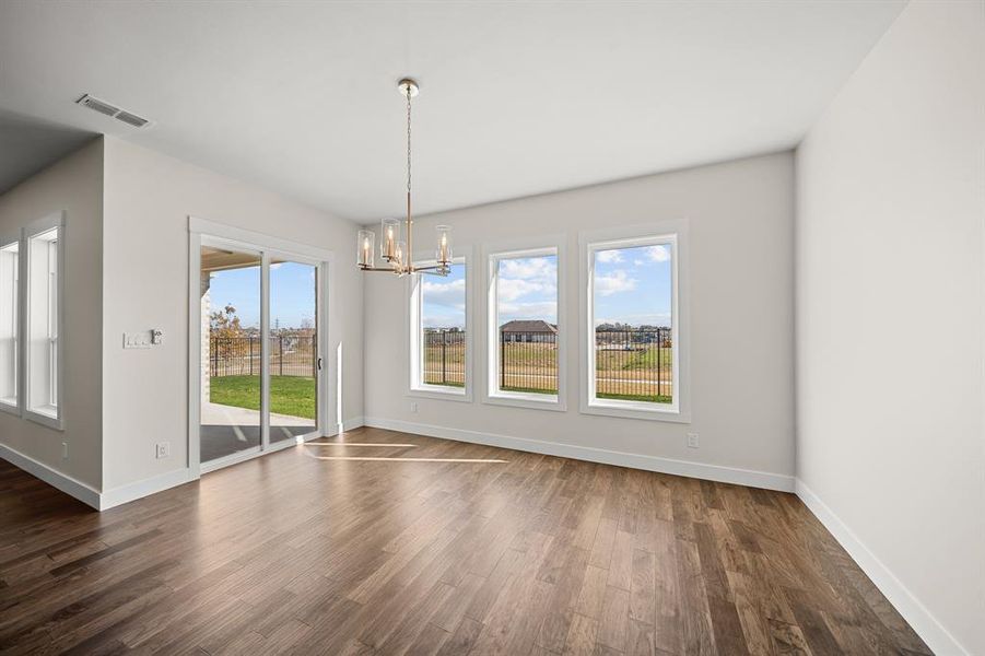 Unfurnished dining area featuring dark wood-style flooring and a chandelier