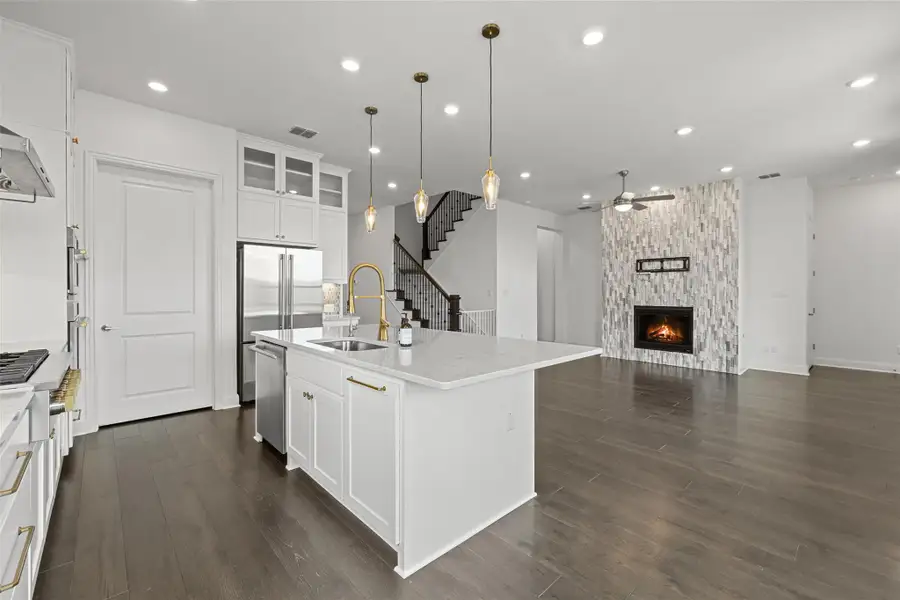 Kitchen with recessed lighting, a sink, dark wood-style floors, light stone counters, and a ceiling fan