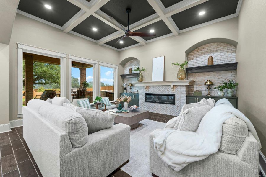 Spacious living area featuring a coffered ceiling with recessed lighting, tile flooring, and a fireplace with a herringbone-patterned surround