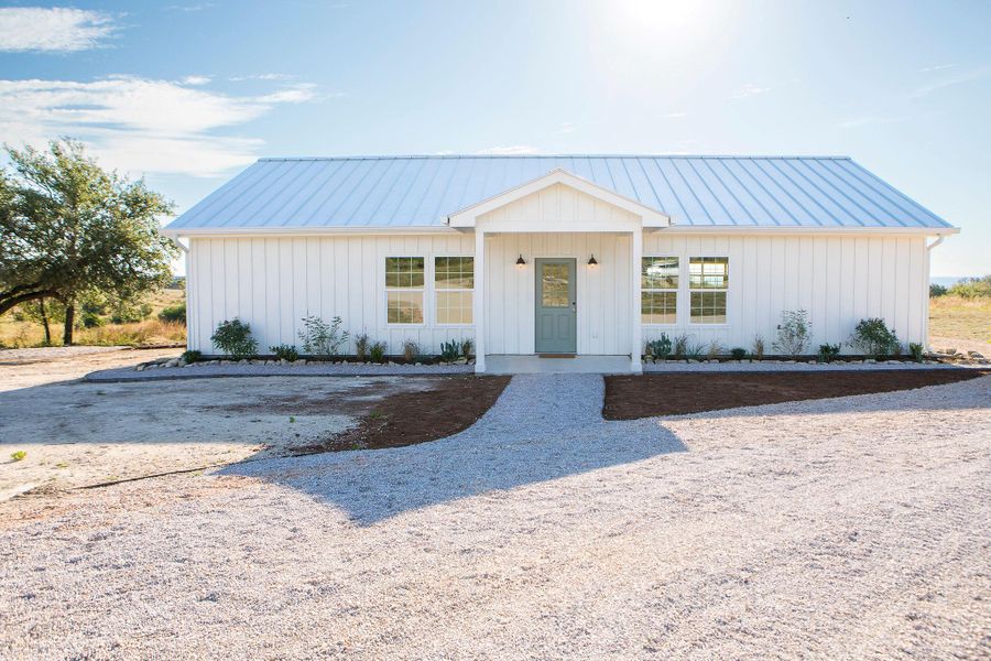 Modern farmhouse with a standing seam roof, covered porch, and a metal roof Modern farmhouse with a standing seam roof, covered porch, and a metal roof