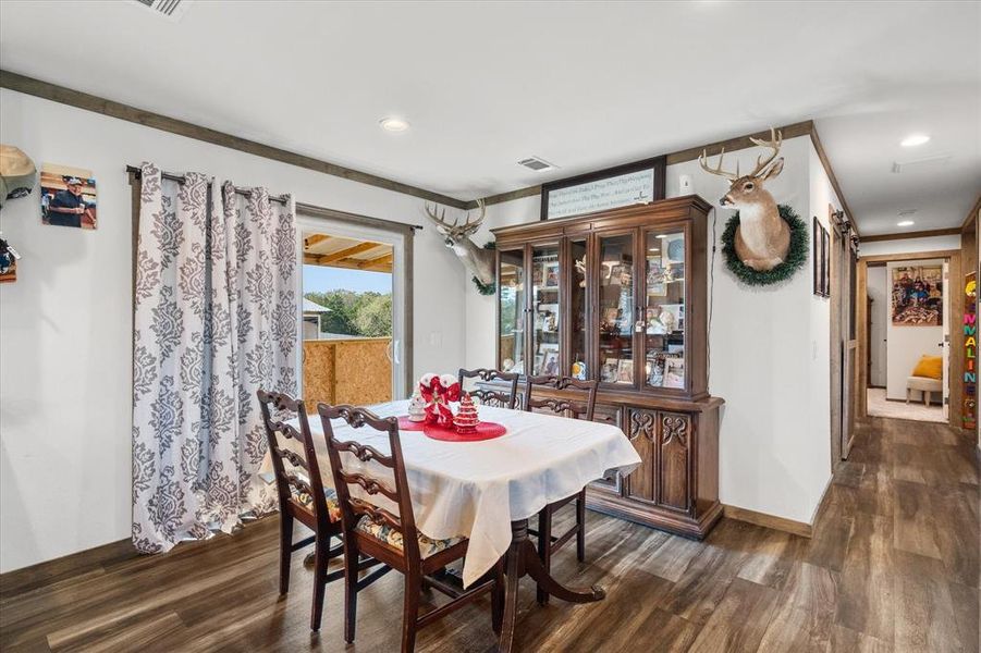 Dining area featuring wood-finish flooring, white walls, and dark wood trim