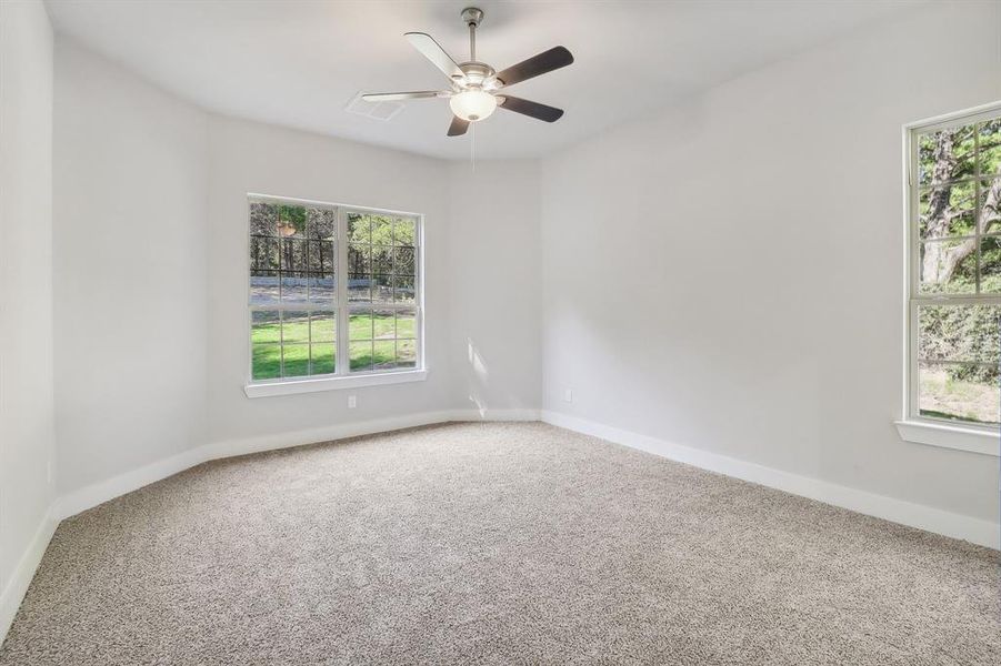 Carpeted spare room featuring ceiling fan