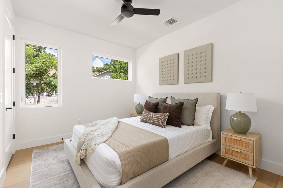 A quiet bedroom retreat with light wood flooring and well-placed natural light sources. A quiet bedroom retreat with light wood flooring and well-placed natural light sources.