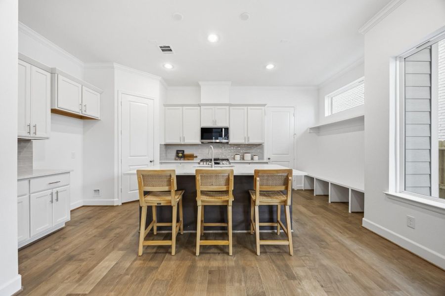 Culinary Excellence: Centered around a generous kitchen island, this modern chef's paradise boasts the latest in sleek stainless steel appliances from LG, marrying function with sophistication.