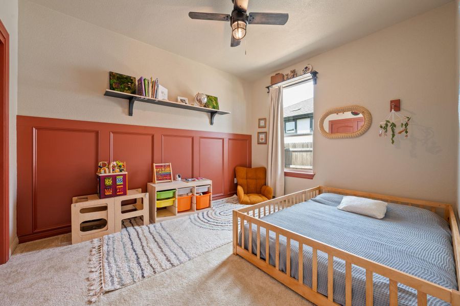 Carpeted bedroom with a decorative wall and a ceiling fan Carpeted bedroom with a decorative wall and a ceiling fan