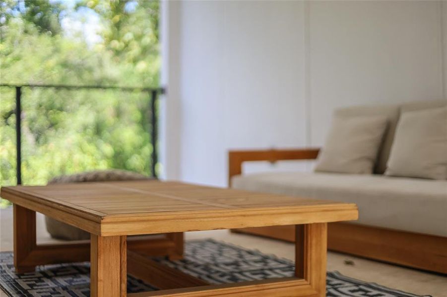An inviting wooden table anchors this covered patio, ideal for peaceful outdoor relaxation.