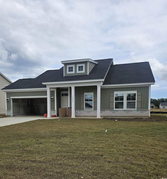 View of front of house with a front lawn, board and batten siding, driveway, roof with shingles, and a porch View of front of house with a front lawn, board and batten siding, driveway, roof with shingles, and a porch