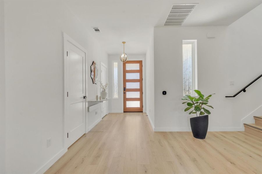 Foyer with baseboards and light wood-type flooring