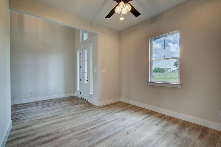 Empty room featuring light wood-type flooring and ceiling fan