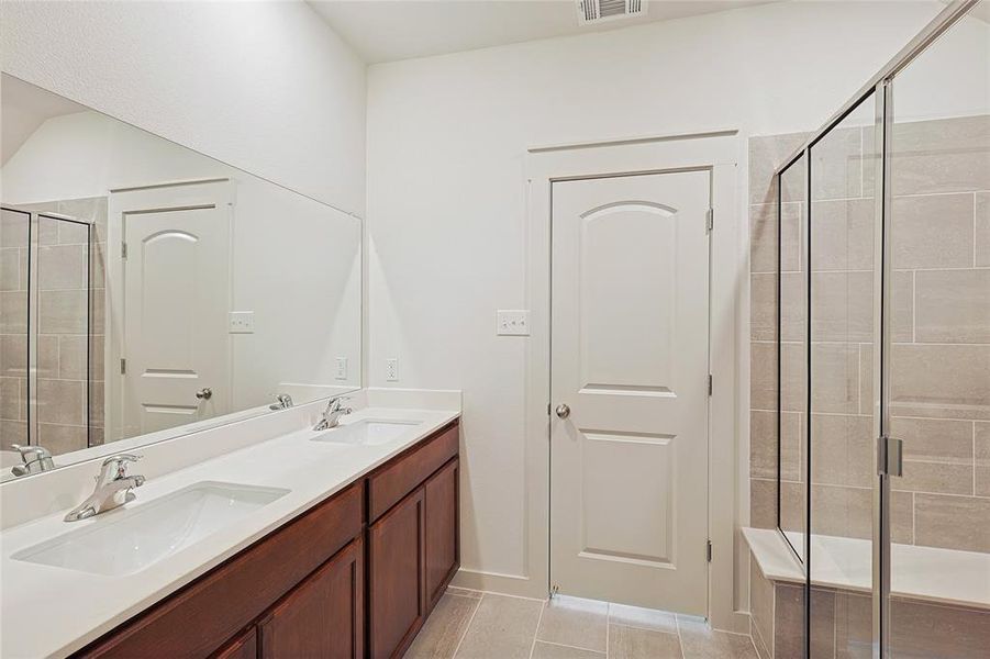 Bathroom featuring vanity, tile patterned flooring, and an enclosed shower