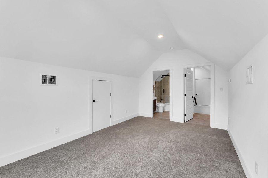 Bonus room featuring carpet floors and vaulted ceiling