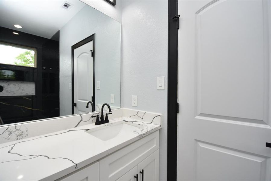 Full bath with a tub-shower combo and quartz countertop, serving one room.