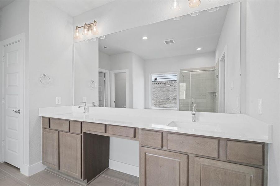 This primary bathroom is definitely move-in ready! Featuring stained cabinets with light countertops, spacious walk-in closet with shelving, high ceilings, custom paint, and sleek modern finishes.