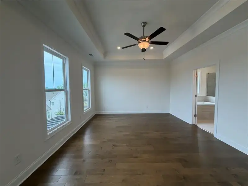 Primary Bedroom with upgraded hardwoods, trey ceilings & Mountain Views *Images shown are from a different homesite featuring the Aspen Floor Plan. Design selections and colors will vary by home. *