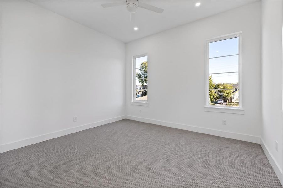 Spare room with carpet flooring, ceiling fan, and a wealth of natural light