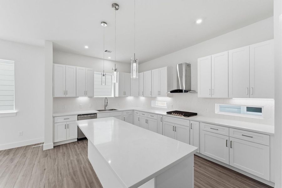 Contemporary kitchen featuring an oversized island, white shaker-style cabinetry, and stainless steel appliances.