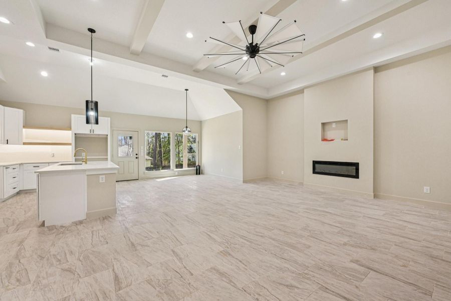 Another view of this stunning space, showcasing the detailed kitchen backsplash, elegant flooring. and charming coffee station.