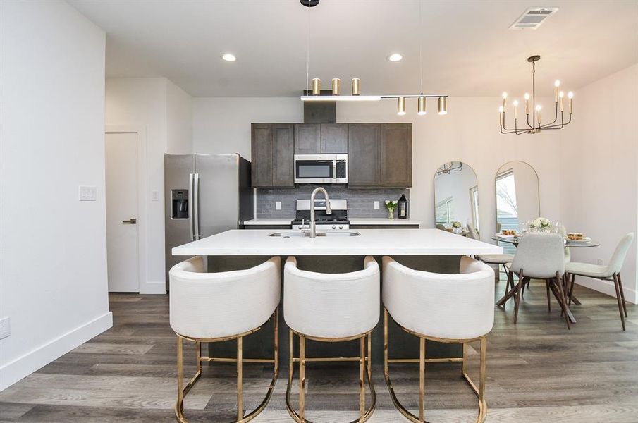 Sleek lines are offered in this beautiful quartz topped island, with extended counter for stools, quick snacks and a great surface for your famous finger foods, when entertaining.