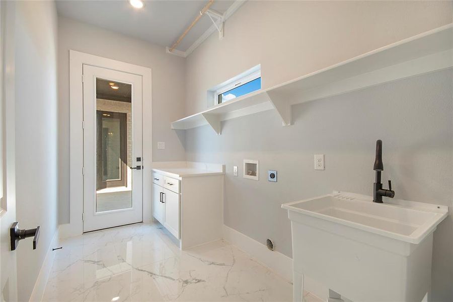 Laundry area featuring washer hookup, light marble finish floors, cabinet space, and recessed lighting Laundry area featuring washer hookup, light marble finish floors, cabinet space, and recessed lighting