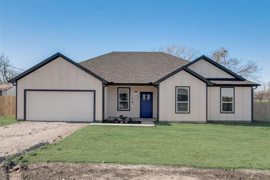 View of front of home with a front yard and a garage