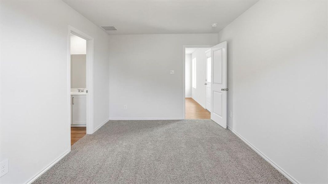 Empty room with light colored carpet and baseboards