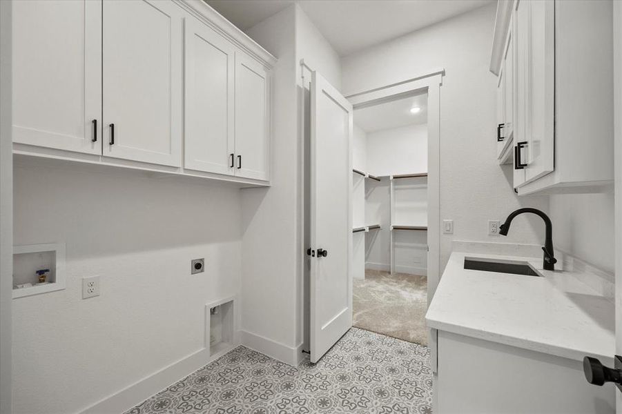 Laundry area with washer hookup, electric dryer hookup, cabinets, and sink