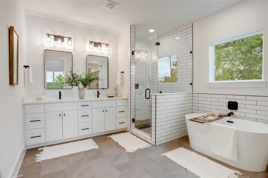 The primary bath has solid wood cabinets, custom lighting, 3cm quartz counters, and Moen fixtures. The primary bath has solid wood cabinets, custom lighting, 3cm quartz counters, and Moen fixtures.