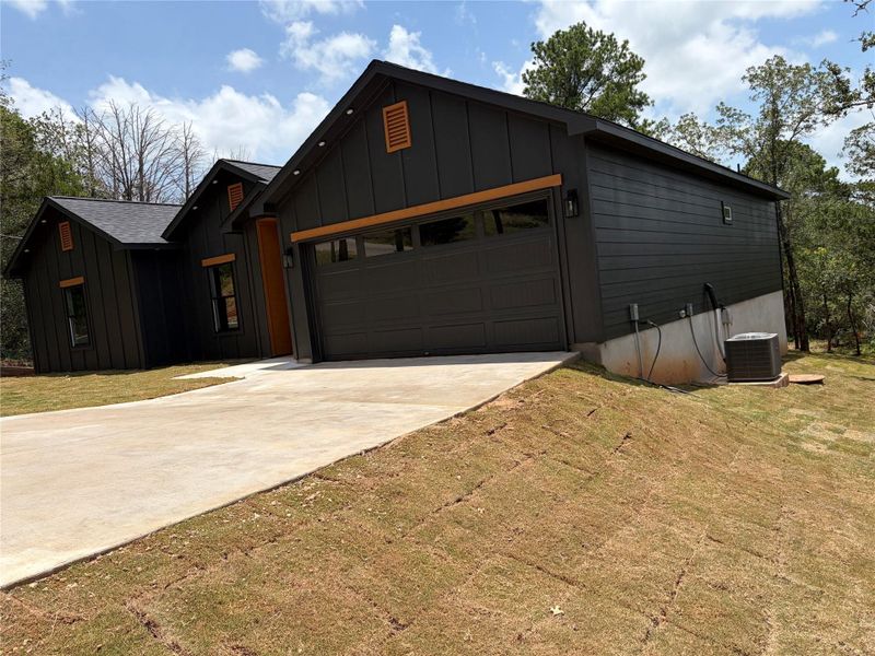 A newly constructed modern dwelling boasts a concrete driveway leading to an integrated garage. A newly constructed modern dwelling boasts a concrete driveway leading to an integrated garage.