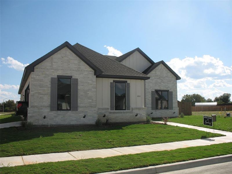 View of front of property featuring brick siding and board and batten siding