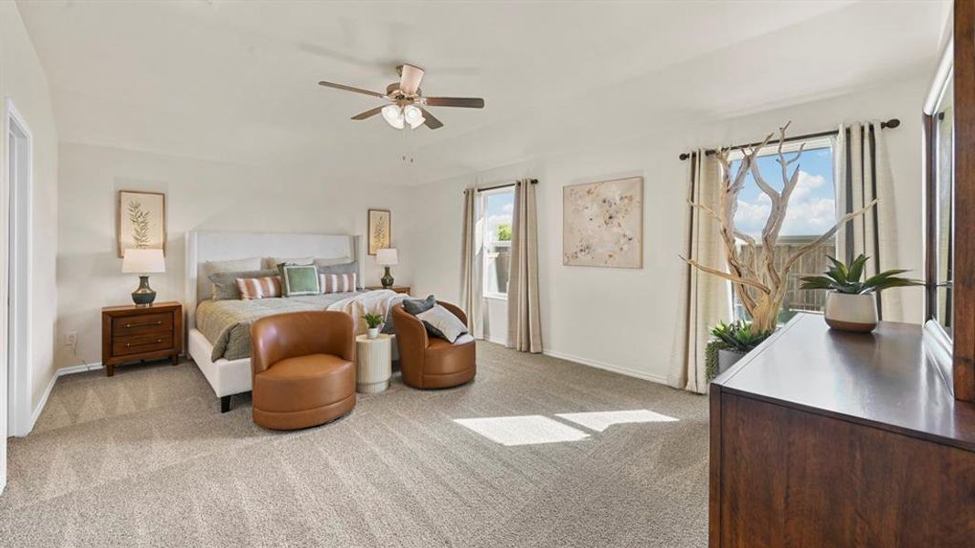 This spacious room features light-colored walls, carpeted flooring, and a ceiling fan