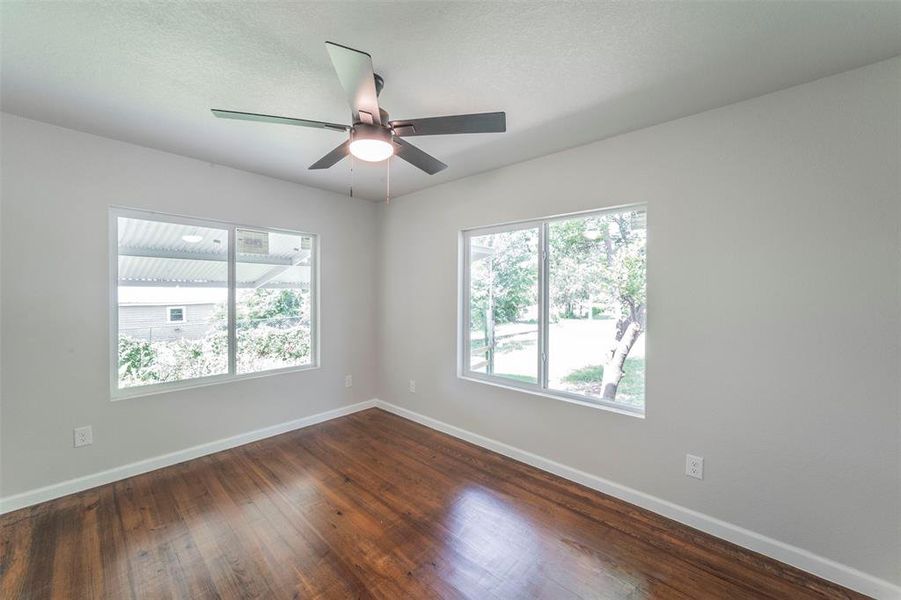 Primary bedroom featuring ceiling fan and hardwood / wood-style flooring