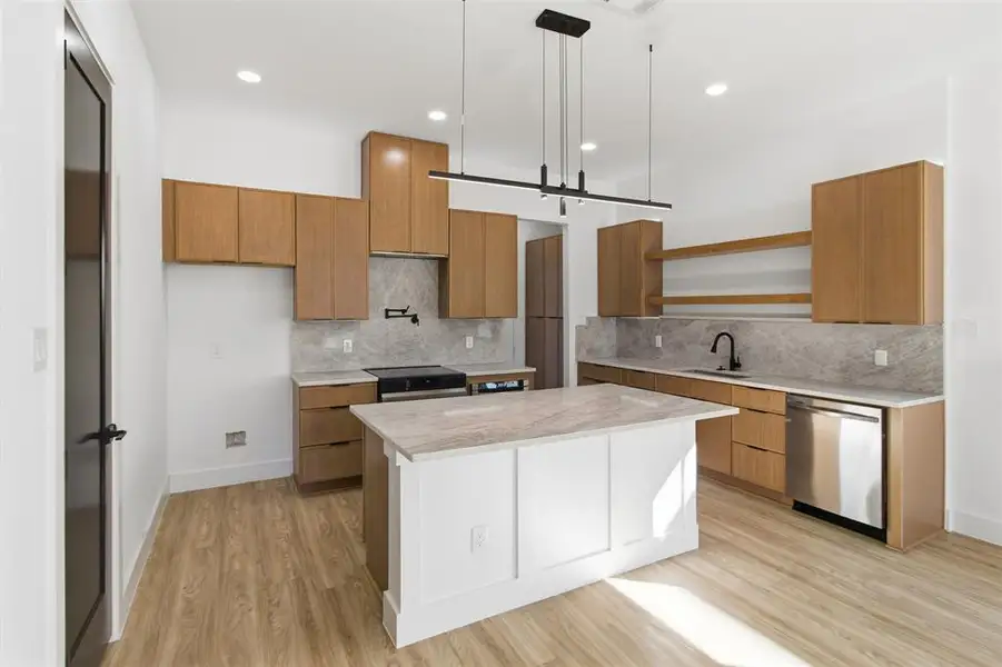 Kitchen featuring wood finish cabinets, stainless steel dishwasher, decorative light fixtures, backsplash, and open shelves