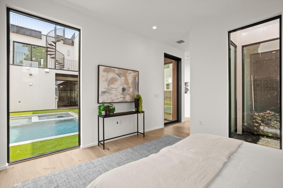 Bedroom featuring access to exterior, light wood-style floors, recessed lighting, and connected bathroom