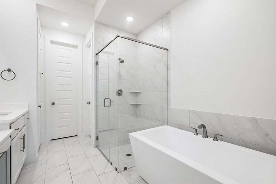 Indulge in the primary bathroom with a luxurious soaking tub and a sleek walk-in shower, creating a modern spa like retreat right at home.
