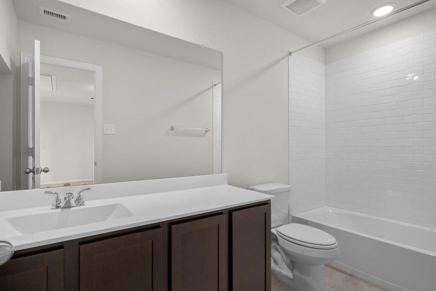 The upstairs bathroom features a sleek modern design with a large mirror, extended vanity, and tub/shower combination. Its bright and clean look provides convenience for family and guests alike. The upstairs bathroom features a sleek modern design with a large mirror, extended vanity, and tub/shower combination. Its bright and clean look provides convenience for family and guests alike.