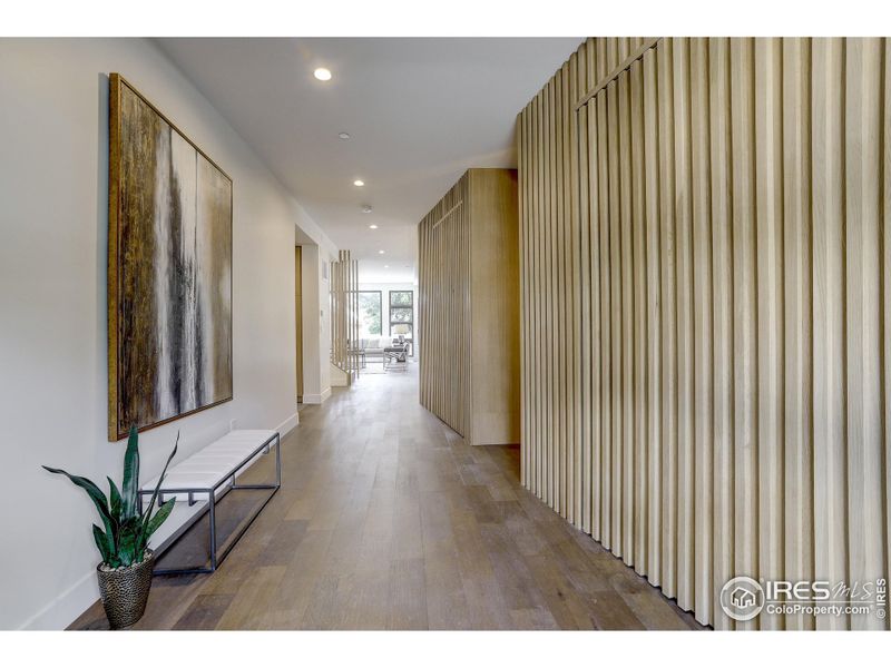 Stunning custom white oak wall with unique in-wall slab oak doors