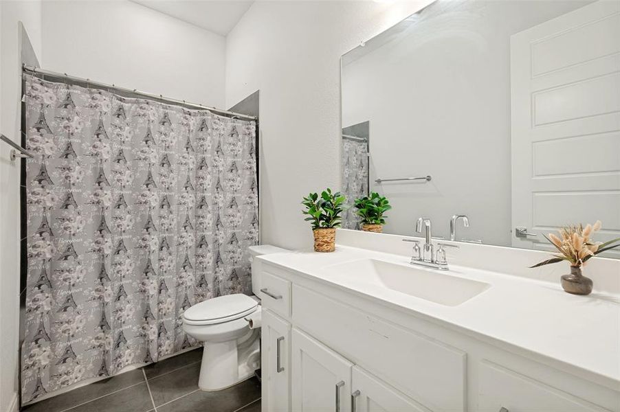 Bathroom featuring a spacious vanity with an integrated sink, polished chrome faucet, and a large mirror